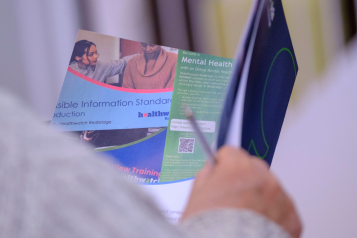 A photo of a person reading a document from Healthwatch Redbridge