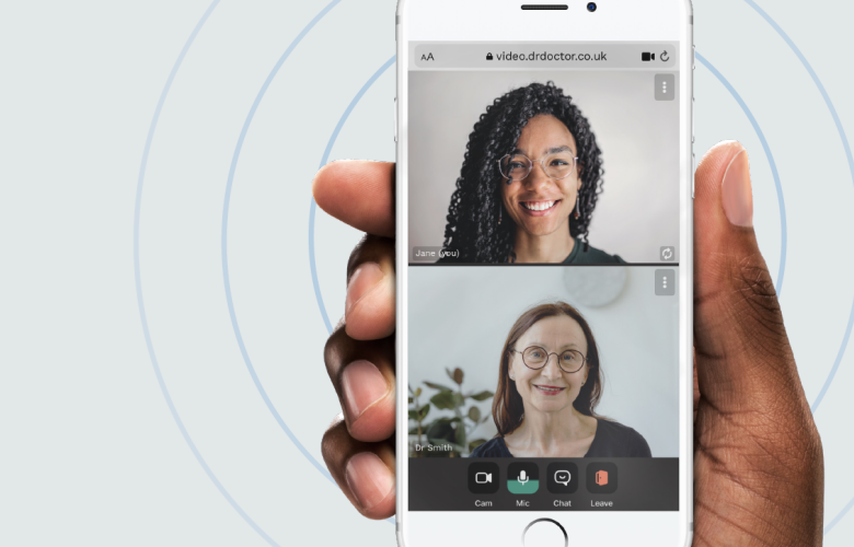 A photo of a hand holding a phone that displays two people on a video call