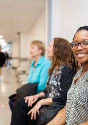 Three women sat waiting in a hospital corridor