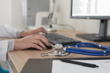 A photo of a doctor at a computer