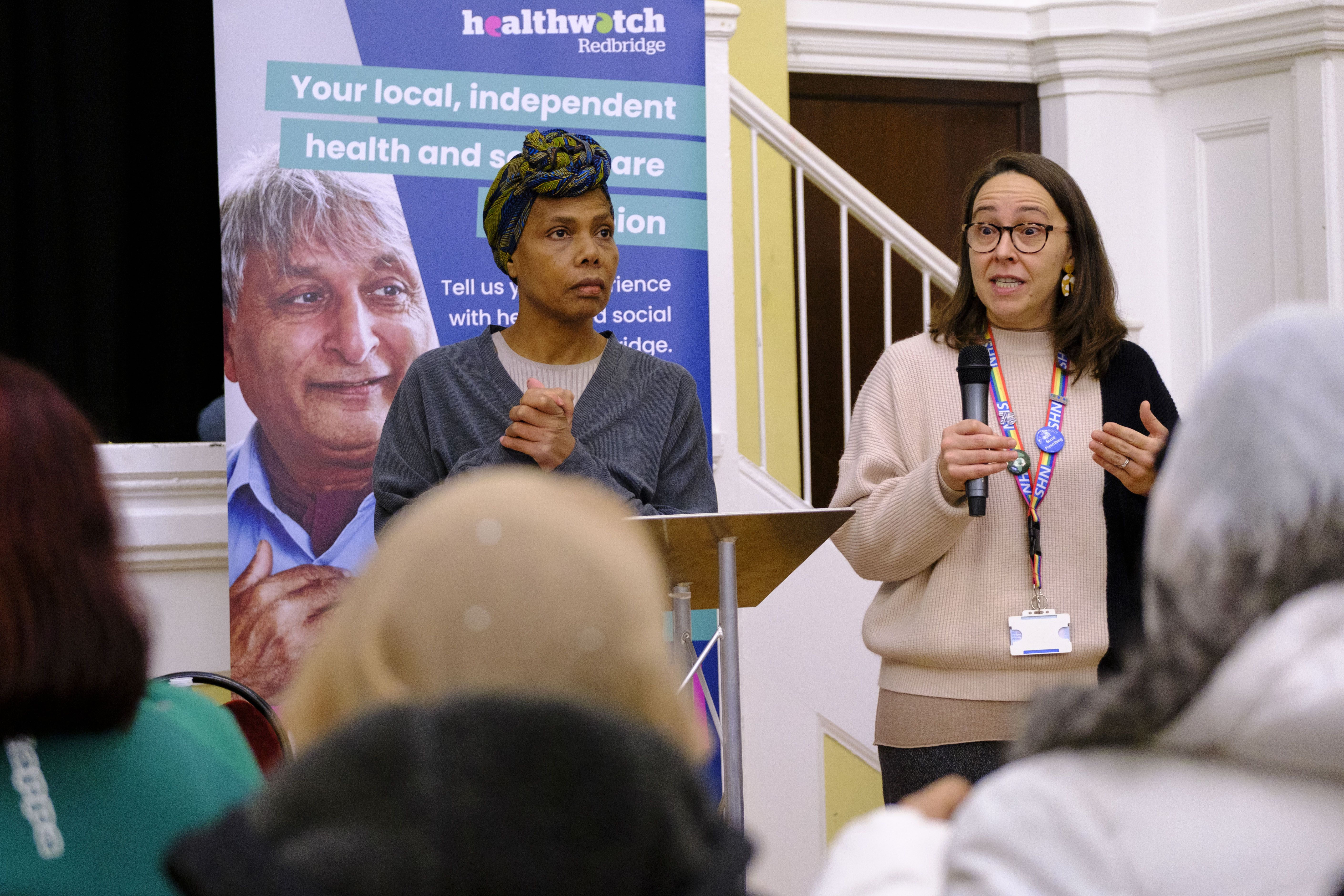 A photo of two women addressing a crowd. 