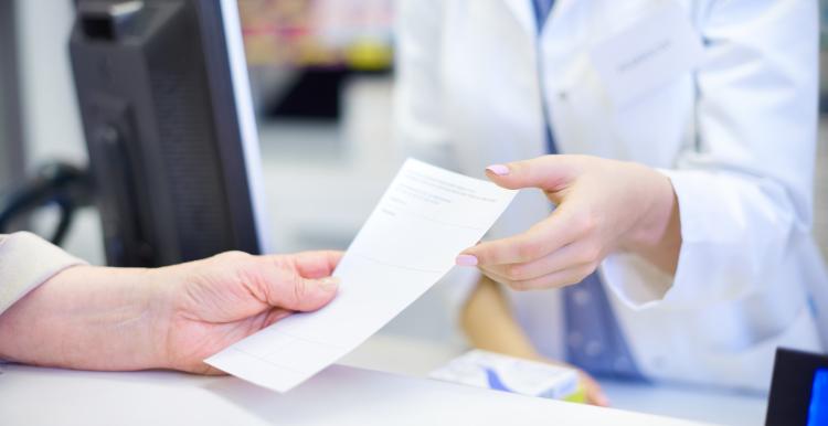 prescription being handed to pharmacist