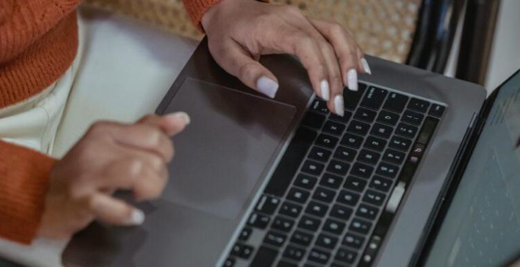 A photo of a person sat at laptop