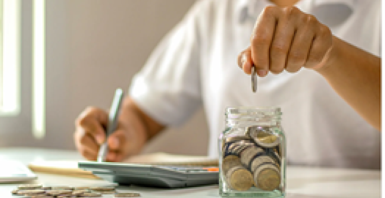 person saving coins in a jar