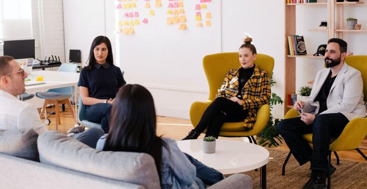 A group of professionals sat in a circle at a meeting