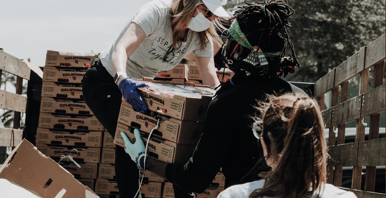 Volunteers offloading food parcels from the back of a truck