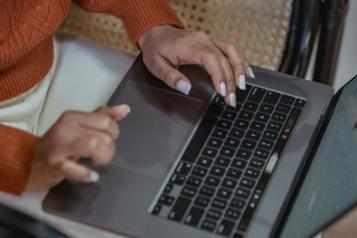 A photo of a person sat at laptop